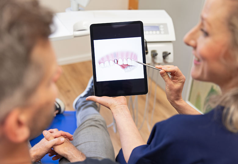 Beratung eines Patienten mithilfe eines Tablets. 